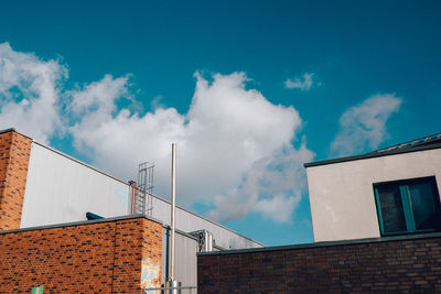 Low angle view of buildings against cloudy sky