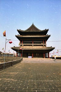 Pathway leading towards temple against sky