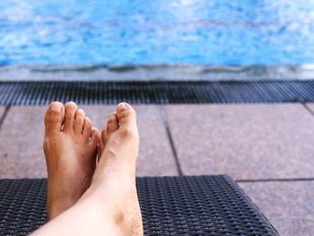 Low section of person resting at poolside