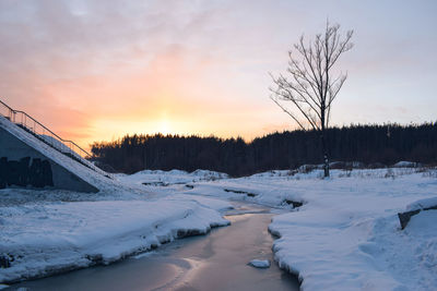 Scenic view of snow covered landscape against sky during sunset