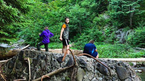 People on rock in forest