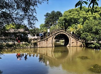 Arch bridge over river against sky