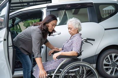Portrait of smiling couple sitting on car