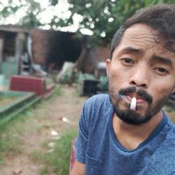 Portrait of young man smoking cigarette