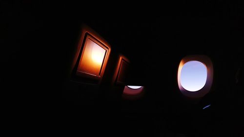 Low angle view of illuminated electric lamp against dark sky