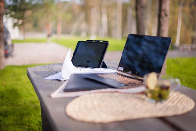 Table and laptop on chair at park