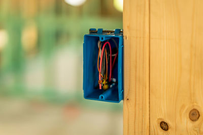 Close-up of clothespins on clothesline against blue wall