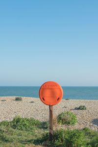 Bright orange lifebuoy on eastbourne beach