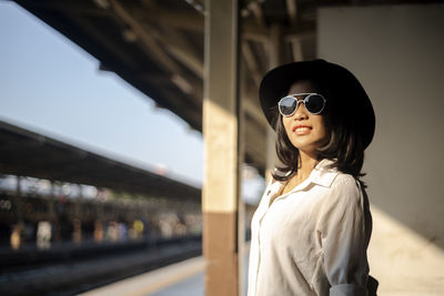 Portrait of woman standing at railroad station