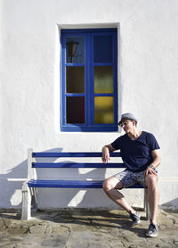 Tourist in mykonos on bench with window