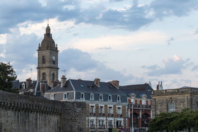 Buildings in city against cloudy sky