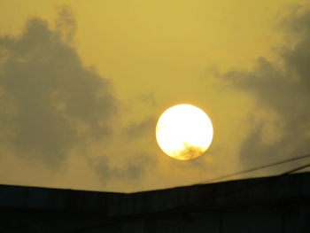 Low angle view of sun shining through clouds