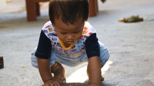 Full length of cute baby boy crouching on floor