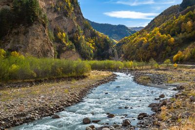 Scenic view of river amidst mountains against sky