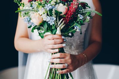 Midsection of woman holding flower bouquet