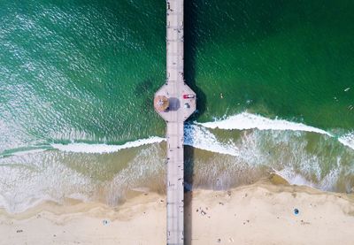 Drone point of view of pier at beach