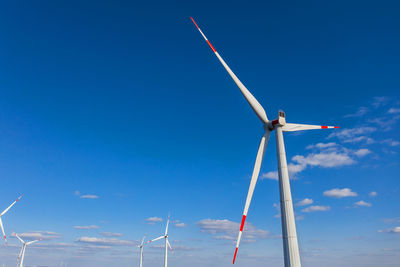 Low angle view of windmill against blue sky