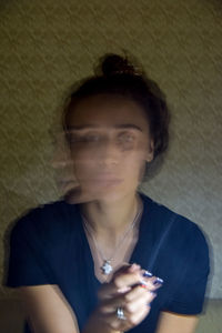 Portrait of man using mobile phone against wall