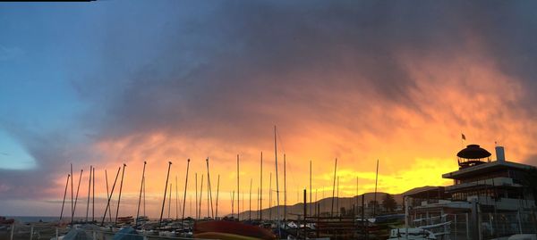 Boats moored at harbor against sky during sunset