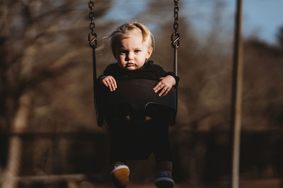 Full length of boy on swing in playground