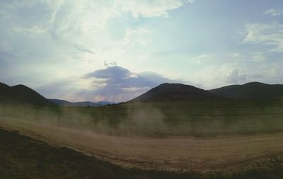 Scenic view of mountains against cloudy sky