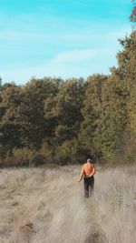 Rear view of man walking on field