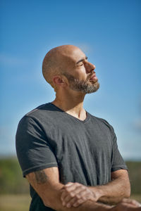 Man looking away against blue sky