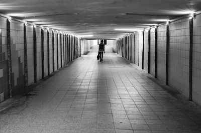 Rear view of man walking in subway tunnel