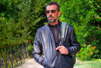 Portrait of man standing against plants