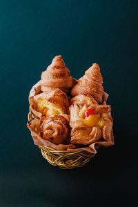 High angle view of bread in basket on table against green background