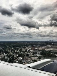 Aerial view of cityscape against cloudy sky