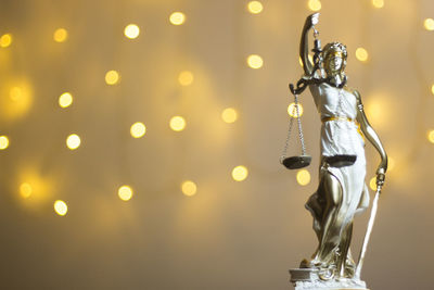 Close-up of lady justice against illuminated lights
