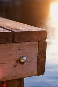 Close-up of ball on wood against sky during sunset