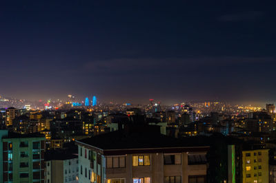 High angle view of illuminated buildings against sky at night