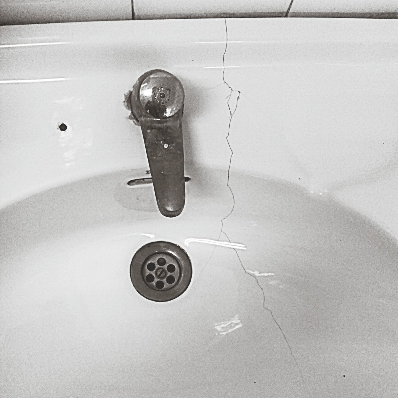 indoors, high angle view, still life, wall - building feature, bathroom, close-up, domestic bathroom, no people, directly above, hygiene, water, reflection, table, white color, flooring, wall, sink, single object, simplicity, empty