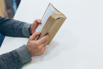 Midsection of person holding book