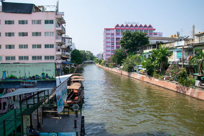 River amidst buildings in city against sky