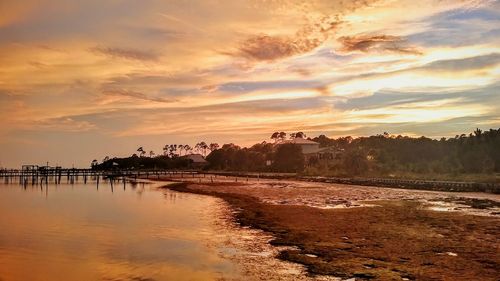 Scenic view of sea against cloudy sky at sunset