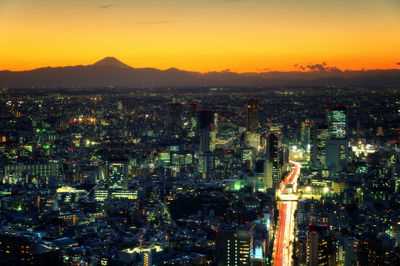 High angle view of illuminated cityscape against sky at night