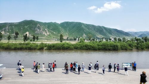 High angle view of people on promenade by river against sky