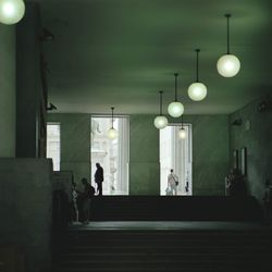 People walking in illuminated building
