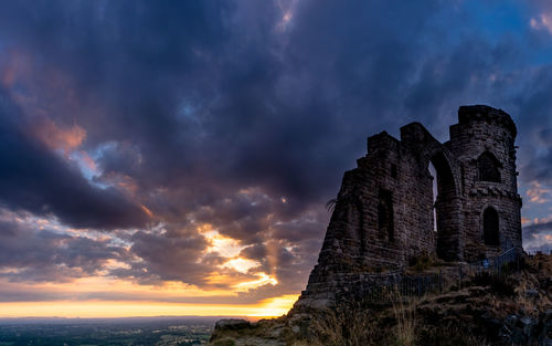 Low angle view of old building against sky during sunset