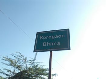 Low angle view of road sign against clear sky