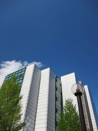 Low angle view of modern buildings against blue sky