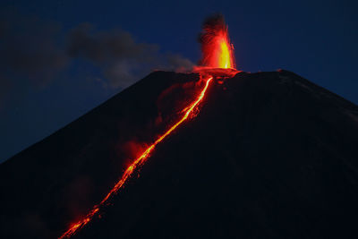 Low angle view of illuminated light trails against sky
