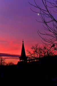 Silhouette of temple and building against sky during sunset