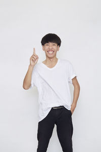 Portrait of smiling man standing against white background