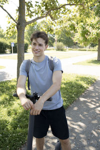 Portrait of young man standing in park