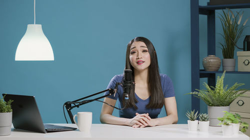 Portrait of woman podcasting in studio