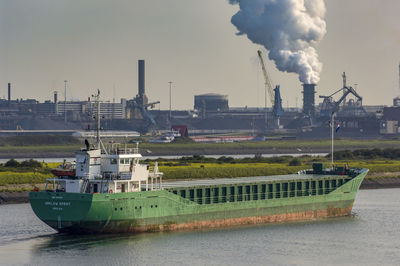 Smoke emitting from factory against sky